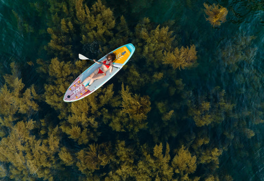 Persona usando una tabla de SUP para iniciarse en paddle surf, ejemplo práctico para elegir la primera tabla